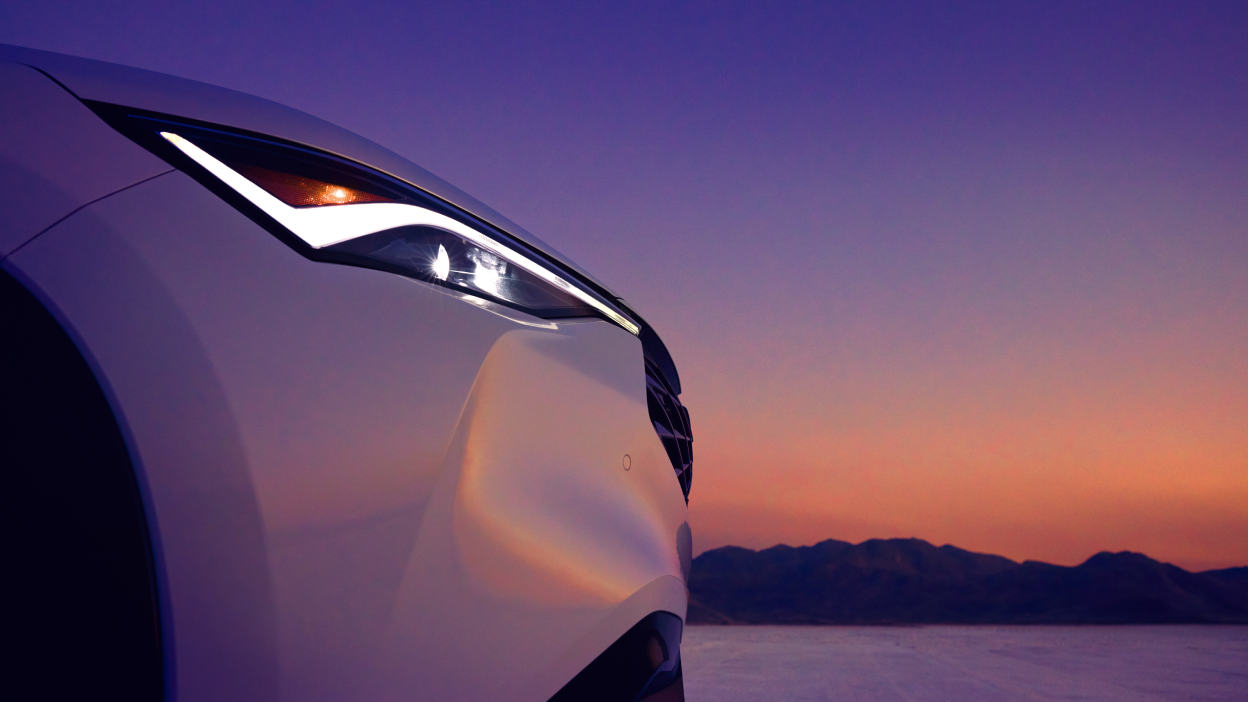 Wide rear-view shot of an Acura ADX with a dusky sunset in the background.
