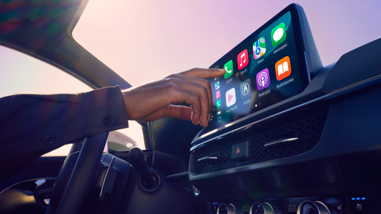 Close-up interior shot of a a driver operating the touchscreen display. 